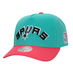 A San Antonio Spurs NBA 47th & 16th All-Time baseball cap in teal and bright pink, featuring a black and white embroidered 'SPURS' logo on the front.