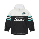A San Antonio Spurs pullover jacket featuring a white upper body, black lower body, and teal and white striped sleeves, with 'San Antonio Spurs' text and a team logo on the chest.