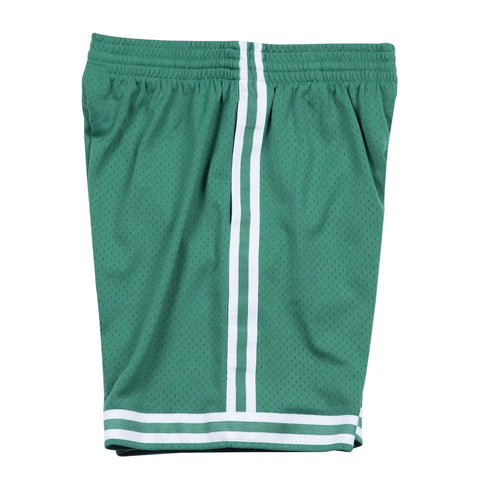 Green athletic shorts with white stripes on a light gray background