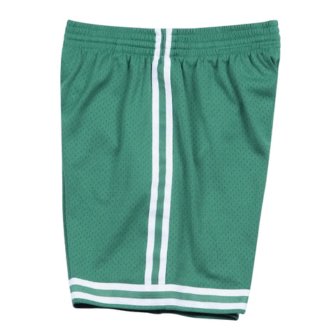 Green athletic shorts with white stripes on a light gray background