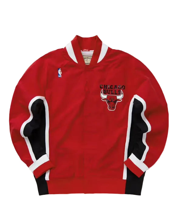 A red Chicago Bulls basketball jacket with black and white striped sleeve panels, featuring the Chicago Bulls logo on the chest and a small NBA logo on the left sleeve.