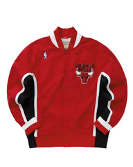 A red Chicago Bulls basketball jacket with black and white striped sleeve panels, featuring the Chicago Bulls logo on the chest and a small NBA logo on the left sleeve.